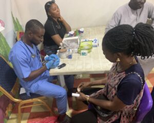 Lab Personnel taking a beneficiaries Sample at Mrs Opeyemi's Birthday held on the 18th of January 2025